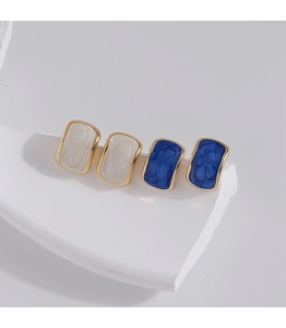 Detail of vintage enamel rectangular stud earrings in beige and blue with gold metal frame