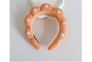 Close-up of orange plush twisted headband with embedded pearls for high crown hairstyling