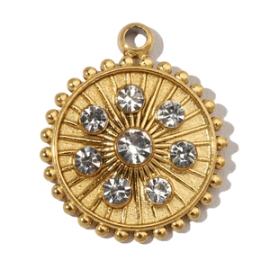 Macro detail of golden circular sunburst charm with sparkling crystals and metal beads