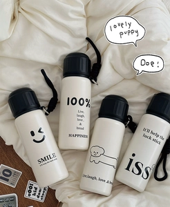 Detail of minimalist stainless steel tea mugs with cartoon prints and black lids