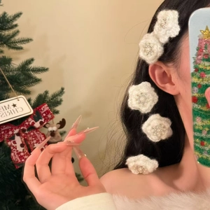 Elegant white knitted flower hair clips with pearls shown in a festive Christmas hair style