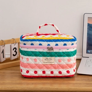 Detailed macro view of a quilted cotton makeup bag with colorful stripes and polka dots