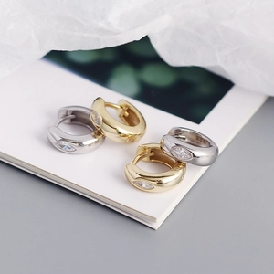 Macro shot of gold and silver S925 sterling silver hoop earrings with marquise zircon