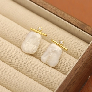 Elegant baroque pearl earrings with gold-plated bar and sparkling zircon in a jewelry box