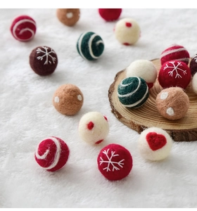 Detailed view of 3cm colorful wool felt Christmas balls with festive embroidery on soft fur