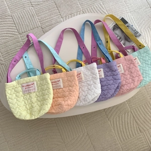 Sacs à main matelassés pour enfants en six couleurs pastel sur une table basse