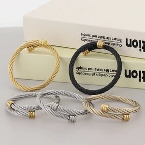 Detailed close-up of colorful stainless steel cable wire bangles in various finishes