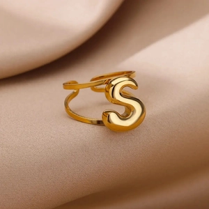 Macro view of gold-plated stainless steel ring featuring a 3D bubble letter S design