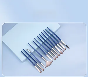 Detailed view of 13-piece dark blue makeup brush set with brown gradient bristles