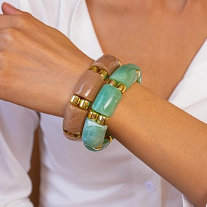 Detail of bohemian acrylic bracelets with marble texture and gold metallic spacers