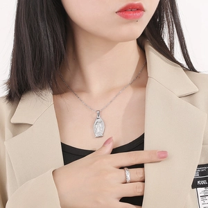 Vista dettagliata della collana Vergine Maria e dell'anello a rilievo su una modella