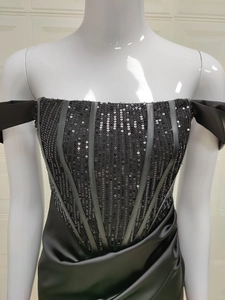 Détail du bustier à paillettes avec baleines et jupe en satin drapé noir élégant