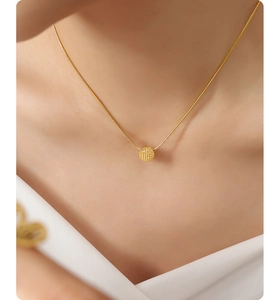 Detail of 18K gold-plated snake chain necklace with engraved Fu character pendant