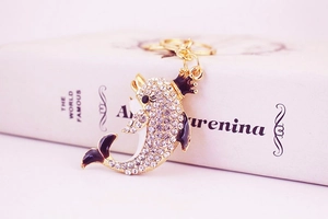 Macro shot of a golden dolphin keychain with rhinestones on a vintage book background