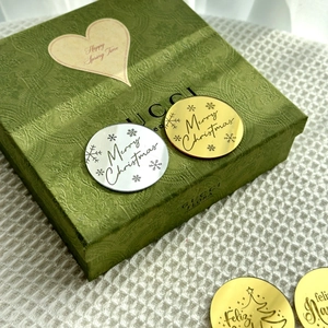 Golden and silver acrylic Feliz Navidad cake toppers with engraved Christmas snowflake motifs