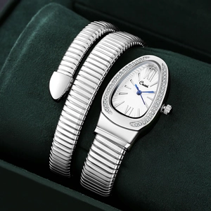 Macro shot of silver snake-shaped quartz watch with crystal bezel on velvet pillow
