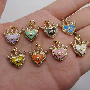 Ciondoli a cuore con occhio del male colorati e zirconi incastonati tenuti in mano