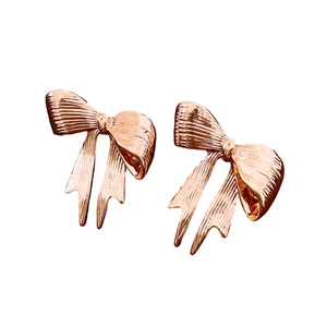 Rose gold bow stud earrings with textured finish shown in a professional white background