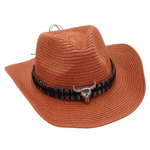 Detail of western straw cowboy hat featuring ethnic band and silver bull skull ornament