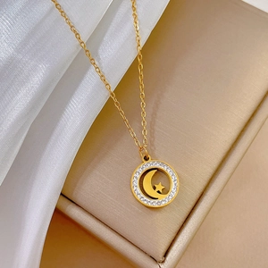 Close-up of gold titanium necklace pendant with star moon charm and sparkling crystals