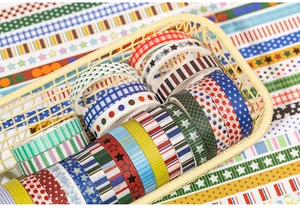 Detail von dekorativen Washi-Tape-Rollen in verschiedenen Mustern in einem kleinen Korb