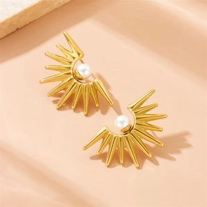 Vintage golden sunburst earrings with pearl inlay on a natural stone surface