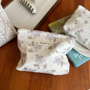 Detailansicht der Stofftasche mit Blumenmuster und Etikett auf rustikalem Holztisch