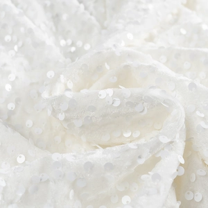 Gros plan détaillé de la texture à paillettes blanches d'une mini robe à nœud