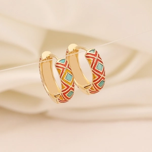 Boucles d'oreilles losanges en émail coloré avec base dorée sur soie beige