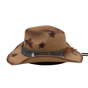 Detail of western straw hat with ethnic beads, tassels, and star print patterns