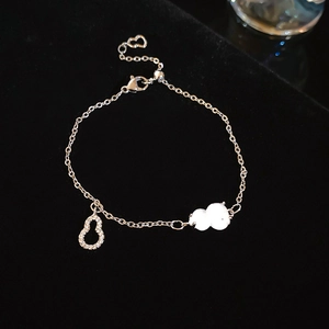 Detail of silver gourd bracelet with white jade pendant and sparkling zircon accents