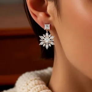 Elegantly worn 14k gold plated snowflake drop earrings with sparkling cubic zirconia