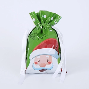 Detail of Christmas drawstring gift bags with cartoon Santa Claus and white ribbon ties