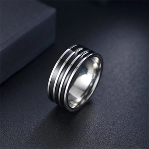 Dettaglio macro di anello in acciaio titanio da uomo con tre strisce in smalto nero
