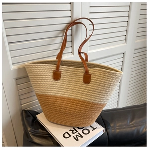 Detail of hand-woven cotton rope tote with premium brown leather handle and stitching