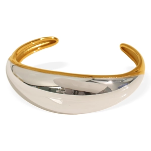 Exaggerated wide two-tone mixed metal open bangle with polished gold and silver finish