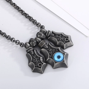Close-up of vintage silver evil eye pendant with triple shield design and textured metal chain