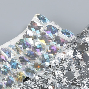 Macro detail of iridescent square rhinestones and silver sequins on elegant party dress