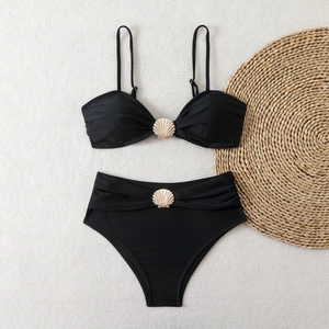 Black bikini set featuring gold shell metal accents and high-waisted bottoms on flat lay