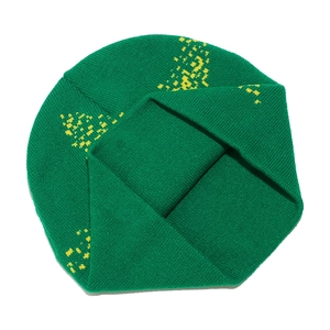 Detail of emerald green knitted beanie with bright yellow star jacquard pattern texture