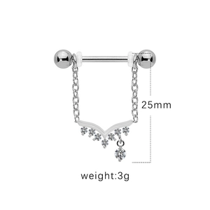 Macro shot of silver barbell piercing with V-shape crystal chain and zircon pendant