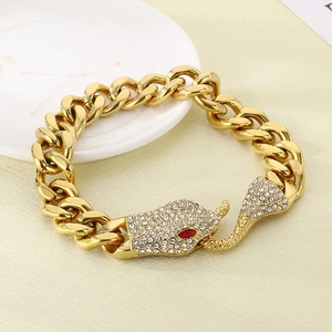 Macro detail of gold snake head cuban link bracelet with red eyes and sparkling crystals