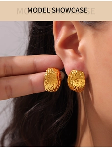 Gros plan détaillé de puces d'oreilles plaquées or 14 carats avec texture martelée