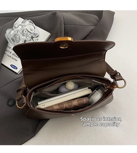 Detail view showing interior capacity and magnetic closure of the vintage leather shoulder bag