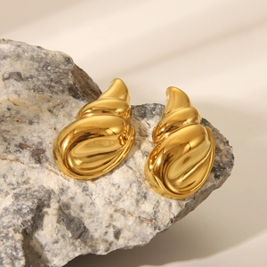 Orecchini a conchiglia dorati lucidi su pietra naturale con elegante gioco di ombre