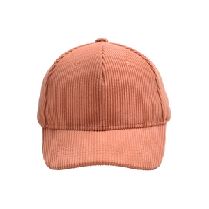 Close-up of the salmon pink corduroy texture and fine stitching on a baseball cap