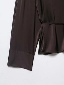 Close-up of silk satin dark coffee blouse showing cuff and belted waist detail