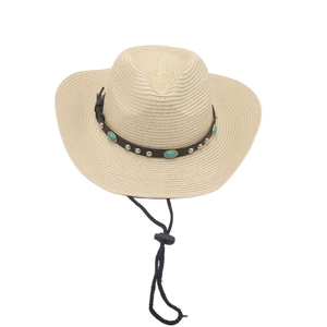 Detail of straw cowboy hat featuring turquoise studs on brown leather band and wind cord