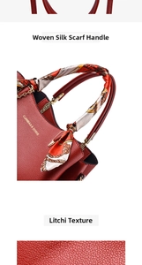 Close-up of red leather handbag with litchi texture, floral scarf handle, and gold logo