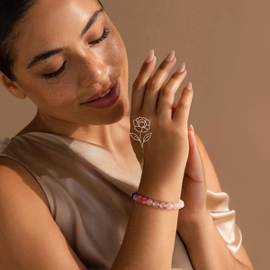 Detail of September natural stone beaded bracelet on wrist with pink and purple crystals
